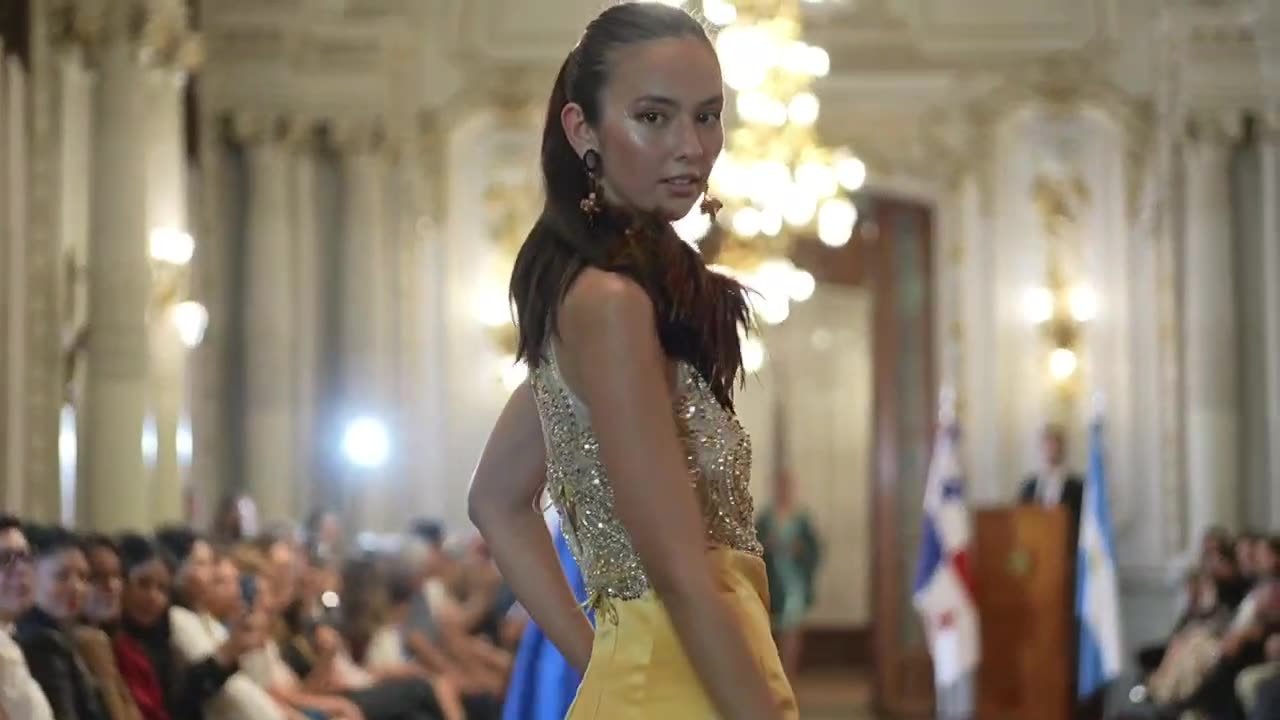 Modelo en pasarela con vestido dorado