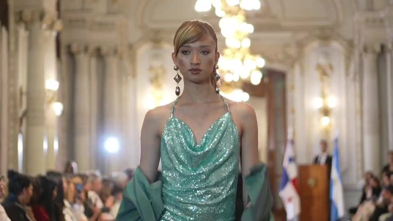 Modelo en pasarela de Latinoamérica Te Viste en un salón con banderas